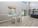 Bright dining area with modern table, large windows, and view of the pool at 6761 Scimitar Ave, Orlando, FL 32812