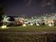 Stunning two-story home with lush lawn and illuminated palm trees at night at 6761 Scimitar Ave, Orlando, FL 32812