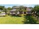 A view of a stunning two-story house featuring a large front yard, mature palm trees, and manicured landscaping at 6761 Scimitar Ave, Orlando, FL 32812