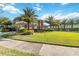 Suburban house showcasing a healthy, green lawn, swaying palms, and groomed landscaping at 6761 Scimitar Ave, Orlando, FL 32812