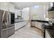 Gourmet kitchen featuring modern appliances, granite countertops, and gray wood flooring at 6761 Scimitar Ave, Orlando, FL 32812