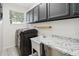Functional laundry room with modern washer and dryer, ample counter space, and storage cabinets at 6761 Scimitar Ave, Orlando, FL 32812