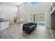 Spacious living room with tall ceilings, grey wood flooring, and views of the pool at 6761 Scimitar Ave, Orlando, FL 32812