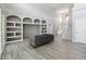 Open-concept living space with custom built-ins and grey wood flooring at 6761 Scimitar Ave, Orlando, FL 32812