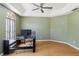 Light-filled home office featuring hardwood floors, modern desk, and a large window at 6761 Scimitar Ave, Orlando, FL 32812