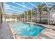 Enjoy this screened-in pool, perfect for relaxing and entertaining with lush landscaping and patio seating at 6761 Scimitar Ave, Orlando, FL 32812