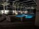 Relaxing screened-in pool area with elegant patio furniture and a spillover spa at night at 6761 Scimitar Ave, Orlando, FL 32812