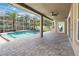 Enclosed pool area with a spacious patio, ceiling fan, landscaping and outdoor access to backyard at 6761 Scimitar Ave, Orlando, FL 32812
