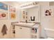 Bright bathroom features a single sink vanity with white cabinets and gray counter, and colorful artwork at 692 Seabrook Ct # 103, Altamonte Springs, FL 32714