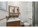 Cozy bathroom featuring a vanity, toilet, and a shower with black tile and chrome fixtures at 80 Lombardy Rd, Winter Springs, FL 32708