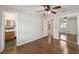 Bedroom with hardwood floors, a ceiling fan, and mirrored closet doors, next to a small ensuite bathroom at 80 Lombardy Rd, Winter Springs, FL 32708