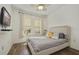Bright bedroom featuring a comfortable bed with two windows and laminate wood floors at 8180 Boat Hook Loop # 105, Windermere, FL 34786