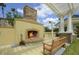 Outdoor fireplace with stone chimney and bench seating, covered by a pergola with columns at 8180 Boat Hook Loop # 105, Windermere, FL 34786