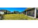 Beautiful backyard view featuring lush green grass, garden beds, and a screened-in porch at 8225 Corkfield Ave, Orlando, FL 32832