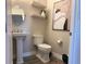 Elegant bathroom featuring a pedestal sink, stylish wall decor, and modern fixtures at 8225 Corkfield Ave, Orlando, FL 32832