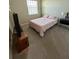 A simple bedroom featuring a queen bed, a television, and neutral carpeting at 8225 Corkfield Ave, Orlando, FL 32832