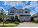 Two-story home featuring a two-car garage, landscaped yard, and covered front porch at 8225 Corkfield Ave, Orlando, FL 32832