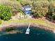 Aerial view of the property featuring a backyard pool, pond with dock, and lush greenery at 835 Dyson Dr, Winter Springs, FL 32708