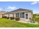 Back exterior view featuring a screened patio and well-maintained landscaping and lawn at 8602 Se 133Rd Ln, Summerfield, FL 34491