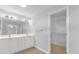 Bathroom showcasing a double sink vanity, large mirror, and a walk-in closet at 8602 Se 133Rd Ln, Summerfield, FL 34491