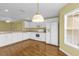 Inviting kitchen featuring white appliances, cabinets, and wood-look flooring with natural lighting at 8602 Se 133Rd Ln, Summerfield, FL 34491
