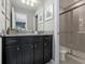 Bathroom featuring granite counters, dark cabinetry, and a glass-enclosed shower at 8892 Bengal Ct, Kissimmee, FL 34747