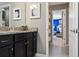 Bathroom featuring granite counters, dark cabinetry, with a view of a blue-themed bedroom at 8892 Bengal Ct, Kissimmee, FL 34747