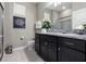 Bathroom featuring granite counters, dark cabinetry, a glass-enclosed shower, and neutral walls at 8892 Bengal Ct, Kissimmee, FL 34747