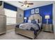 A bedroom featuring a neutral-toned bed frame, stylish blue accents, and matching nightstands at 8892 Bengal Ct, Kissimmee, FL 34747