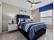 Bedroom featuring a blue upholstered headboard, side tables, and ceiling fan at 8892 Bengal Ct, Kissimmee, FL 34747