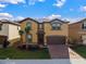 Charming two-story home with a tile roof, brick paved driveway, well-manicured lawn and a two car garage at 8892 Bengal Ct, Kissimmee, FL 34747