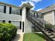 Attractive condo exterior with black shutters, green grass, and black railing up the stairs at 9021 Lee Vista Blvd # 1707, Orlando, FL 32829