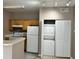 Bright kitchen with white appliances, wooden cabinets, and stacked washer and dryer at 9021 Lee Vista Blvd # 1707, Orlando, FL 32829