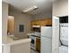 Bright kitchen with white appliances, wooden cabinets and tile backsplash at 9021 Lee Vista Blvd # 1707, Orlando, FL 32829