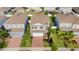 Aerial view of a two-story home with well-maintained landscaping, brick driveway and attached two car garage at 903 Sydney St, Davenport, FL 33837