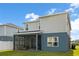 Backyard exterior of the home featuring a screened-in patio and green lawn at 903 Sydney St, Davenport, FL 33837