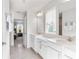 Bathroom with double sink vanity, white cabinets, and view into bedroom through doorway at 903 Sydney St, Davenport, FL 33837
