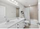 Bright bathroom with a double sink vanity, white cabinets, and shower-tub combination with neutral tile at 903 Sydney St, Davenport, FL 33837