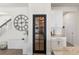 Inviting entryway with stairs, a decorative wall clock, and a view into the pantry and kitchen at 903 Sydney St, Davenport, FL 33837
