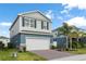 Charming two-story home with a brick driveway, two car garage and tropical landscaping at 903 Sydney St, Davenport, FL 33837