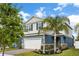 Beautiful two-story home featuring a brick driveway, two car garage and tropical landscaping at 903 Sydney St, Davenport, FL 33837