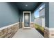 Charming front porch with stone accents, 'Welcome' sign, and decorative front door at 903 Sydney St, Davenport, FL 33837