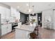 Bright kitchen showcasing a large island, modern lighting, and views of the dining area at 903 Sydney St, Davenport, FL 33837