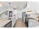 Bright and modern kitchen with white cabinets, stainless steel appliances, and a view of the pantry at 903 Sydney St, Davenport, FL 33837