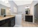 Bright bathroom with granite countertops, dual sinks, dark cabinetry and modern fixtures at 9330 Meadow Hunt Way, Winter Garden, FL 34787