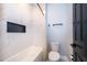 Bathroom featuring modern design, white marble tile, black fixtures, and a bathtub at 9330 Meadow Hunt Way, Winter Garden, FL 34787