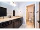 Bathroom with granite countertop vanity, wood floors, and toilet behind open black door at 9330 Meadow Hunt Way, Winter Garden, FL 34787