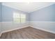 Bright bedroom with hardwood floors, blue accent wall, and natural light from the window at 9330 Meadow Hunt Way, Winter Garden, FL 34787