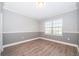 Bedroom featuring wood floors, chair rail and neutral paint colors and a window with blinds at 9330 Meadow Hunt Way, Winter Garden, FL 34787