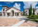 Exterior view of clubhouse entrance featuring stone accents, arched entryway, and manicured landscaping at 9330 Meadow Hunt Way, Winter Garden, FL 34787